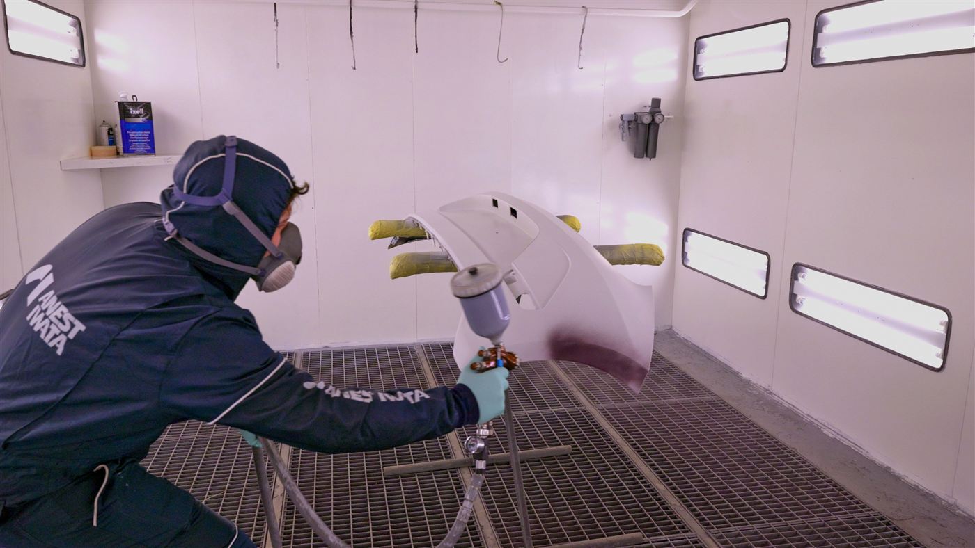 José, notre peintre, applique la peinture au pistolet en cabine à Porto-Vecchio